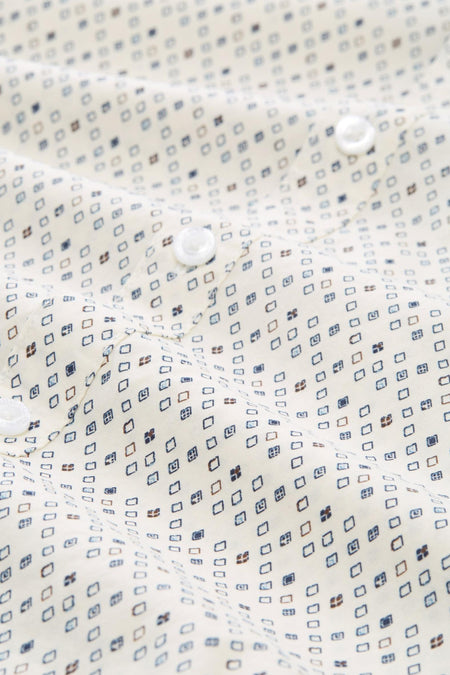 Chemise à manches longues blanche par Tom Tailor, à motifs losanges bleus et marron, avec boutons blancs.
