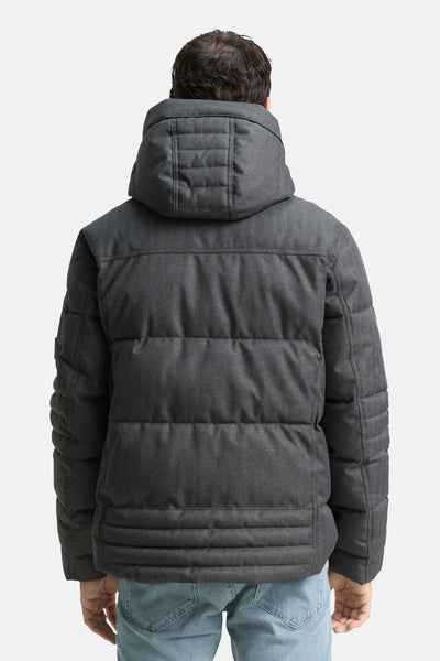 Imperméable gris de Tom Tailor, matelassé avec capuche et motif à chevrons, porté avec un jean clair.