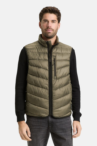 Veste sans manches kaki de Tom Tailor, avec fermeture éclair centrale, portée sur un pull noir et un jean gris délavé.