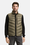 Veste sans manches kaki de Tom Tailor, avec fermeture éclair centrale, portée sur un pull noir et un jean gris délavé.