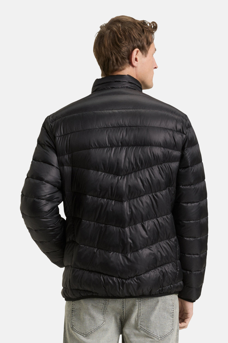 Zwarte regenjas van Tom Tailor met doorgestikt patroon, achtergezicht, gedragen met een grijze jeans.