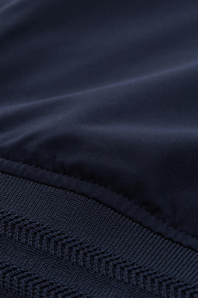 Veste courte bleue de Tom Tailor avec détail de tricot à chevrons en bas.