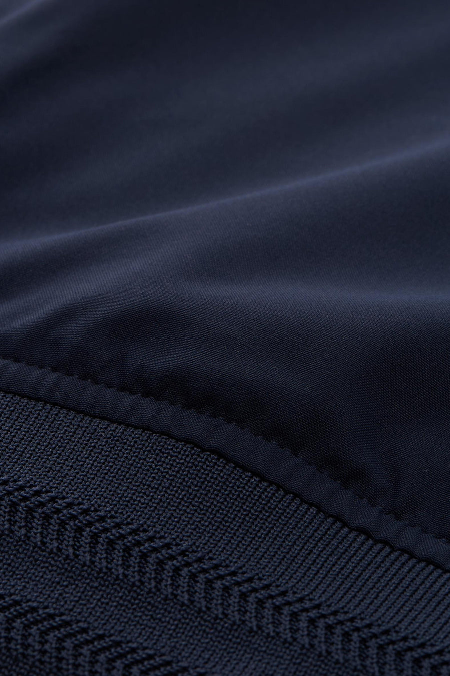 Veste courte bleue de Tom Tailor avec détail de tricot à chevrons en bas.
