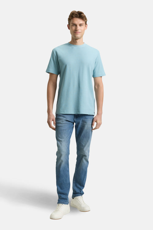 T-shirt à manches courtes bleu de Tom Tailor, porté avec un jean et des baskets blanches.