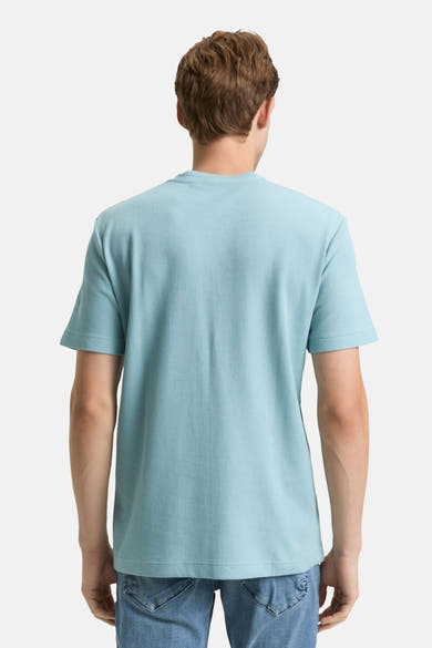 T-shirt bleu à manches courtes de Tom Tailor, texture gaufrée, porté avec un jean, vue de dos.
