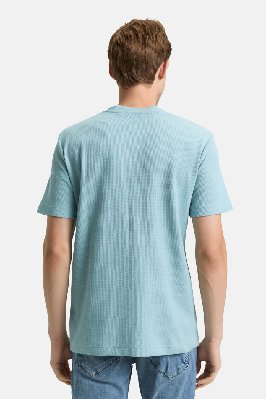 T-shirt bleu à manches courtes de Tom Tailor, texture gaufrée, porté avec un jean, vue de dos.
