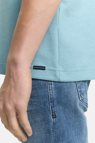 Blauw T-shirt met korte mouwen van Tom Tailor, in wafelbreisel, gedragen met een spijkerbroek.