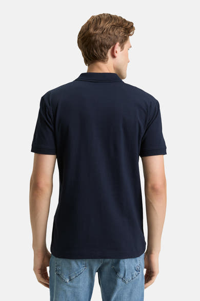 Marineblaues Poloshirt mit kurzen Ärmeln von Tom Tailor, getragen mit Jeans, Rückansicht.
