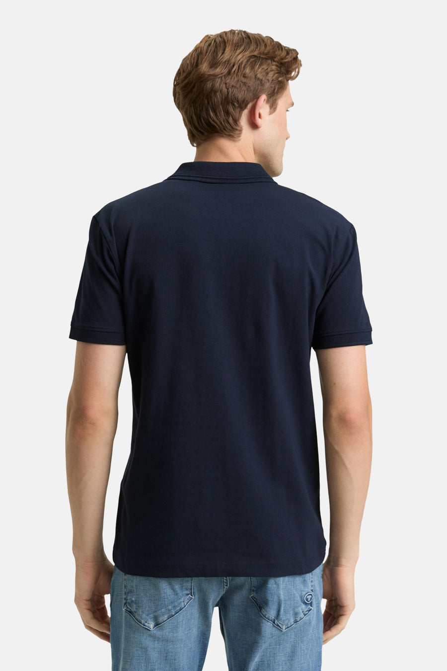 Marineblaues Poloshirt mit kurzen Ärmeln von Tom Tailor, getragen mit Jeans, Rückansicht.