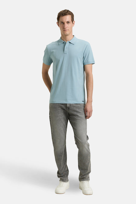Polo bleu à manches courtes de Tom Tailor, porté avec un jean gris et des baskets blanches.