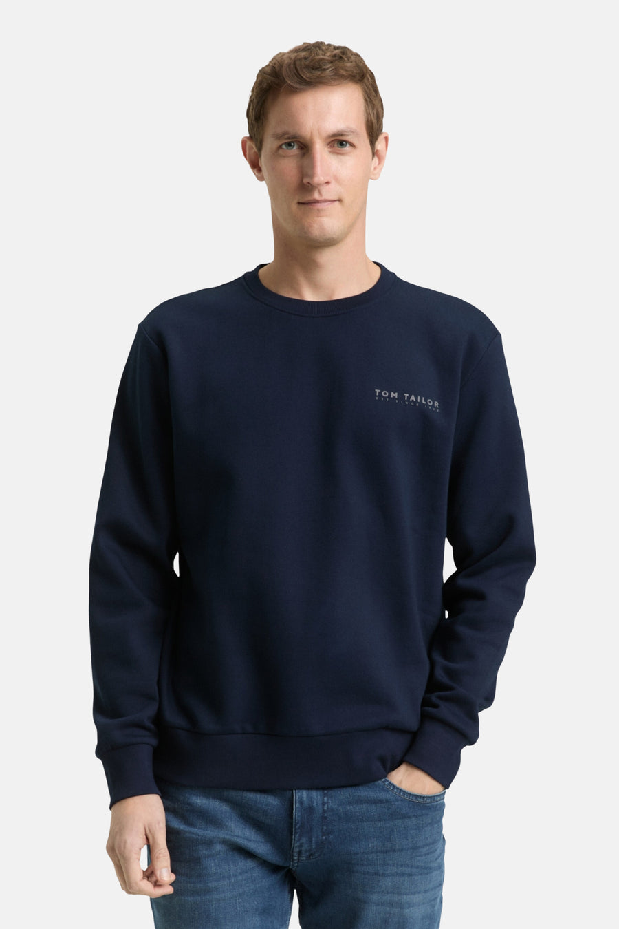Blauwe sweater van Tom Tailor, gedragen met een blauwe jeans en witte sneakers.