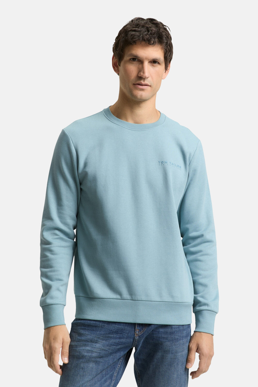 Blauwe sweater van Tom Tailor, achterkant, gedragen met een klassieke blauwe spijkerbroek.