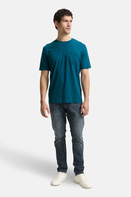 T-shirt turquoise à manches courtes de Tom Tailor, avec poche poitrine, porté avec un jean et des baskets blanches.