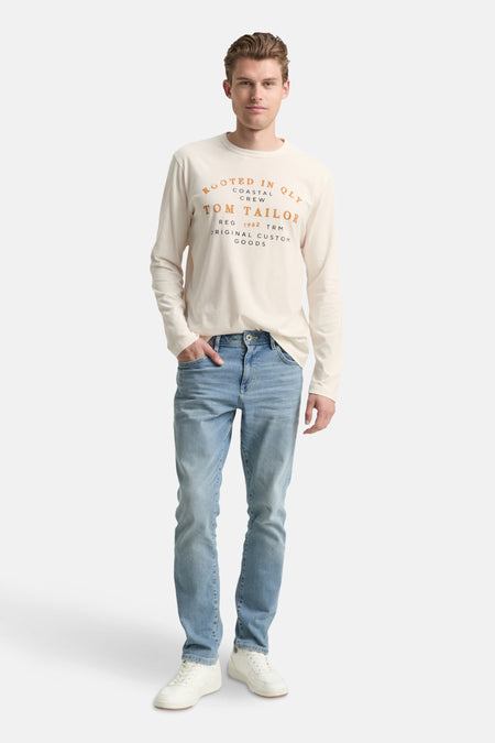T-shirt à manches longues blanc de Tom Tailor, porté avec un jean bleu clair et des baskets blanches.