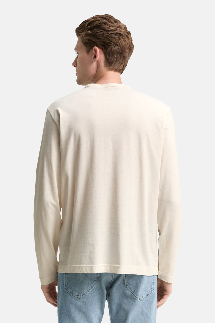 Witte T-shirt met lange mouwen van Tom Tailor, gedragen met een lichtblauwe jeans, achtergezicht.