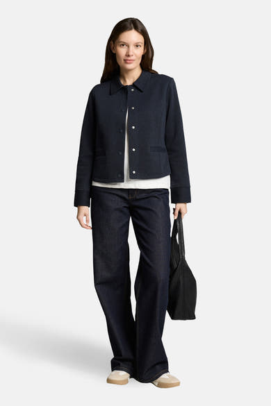 Blazer bleu marine de Tom Tailor, porté avec un t-shirt blanc, un jean large et un sac noir.