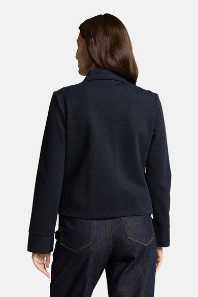 Blazer bleu de Tom Tailor, avec une texture discrète, porté avec un pantalon en denim foncé, vue de dos.
