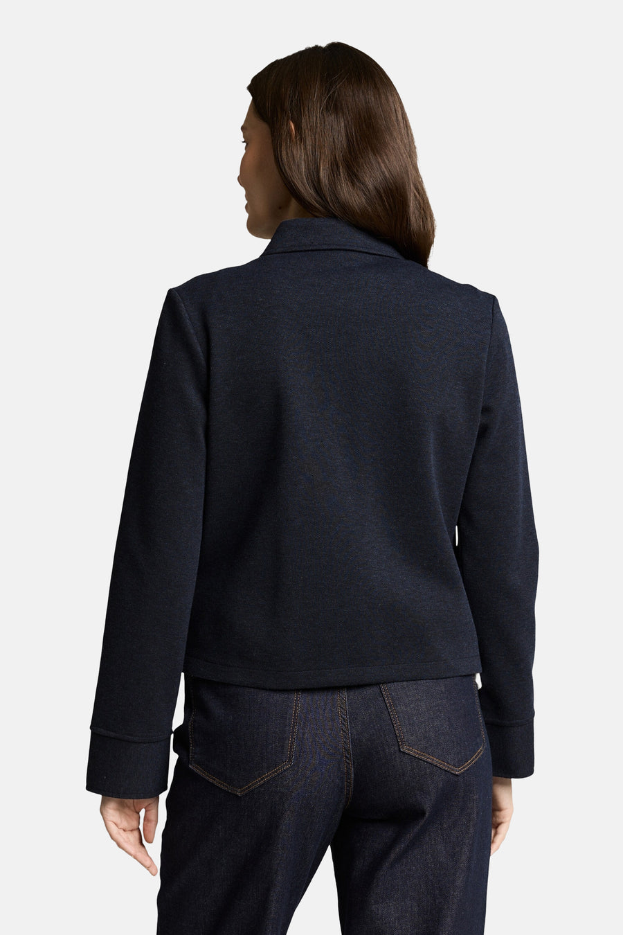 Blazer bleu de Tom Tailor, avec une texture discrète, porté avec un pantalon en denim foncé, vue de dos.
