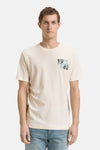 Ecru T-shirt met korte mouwen van Tom Tailor, met een decoratief logo op de borst, gedragen met een blauwe jeans en witte sneakers.