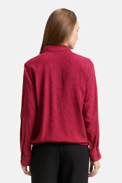 Chemisier rose de Tom Tailor à fines rayures verticales texturées, vue de dos, porté avec un pantalon noir.