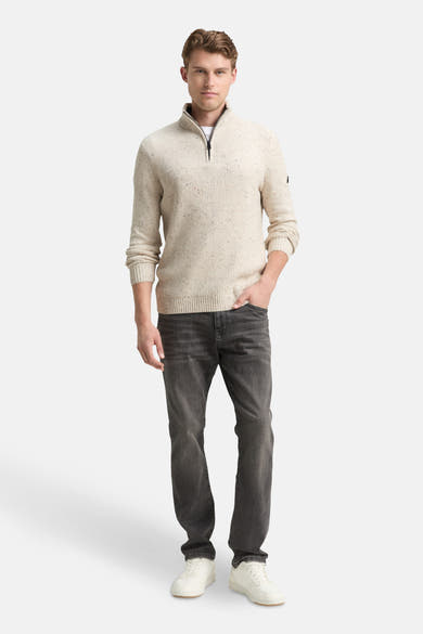 Pull à col roulé écru de Tom Tailor, porté avec un t-shirt blanc et un jean foncé.