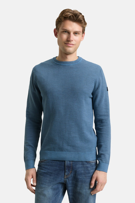 Ronde hals trui blauw van Tom Tailor, gedragen met een spijkerbroek en zwarte schoenen.