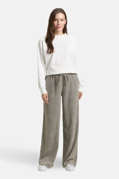 Jogging multicolore de Tom Tailor, à larges jambes et taille à cordon, porté avec un pull blanc uni et des baskets blanches.