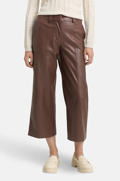 Bruine broek van imitatieleer van Tom Tailor, gedragen met een beige trui en plateau-loafers.