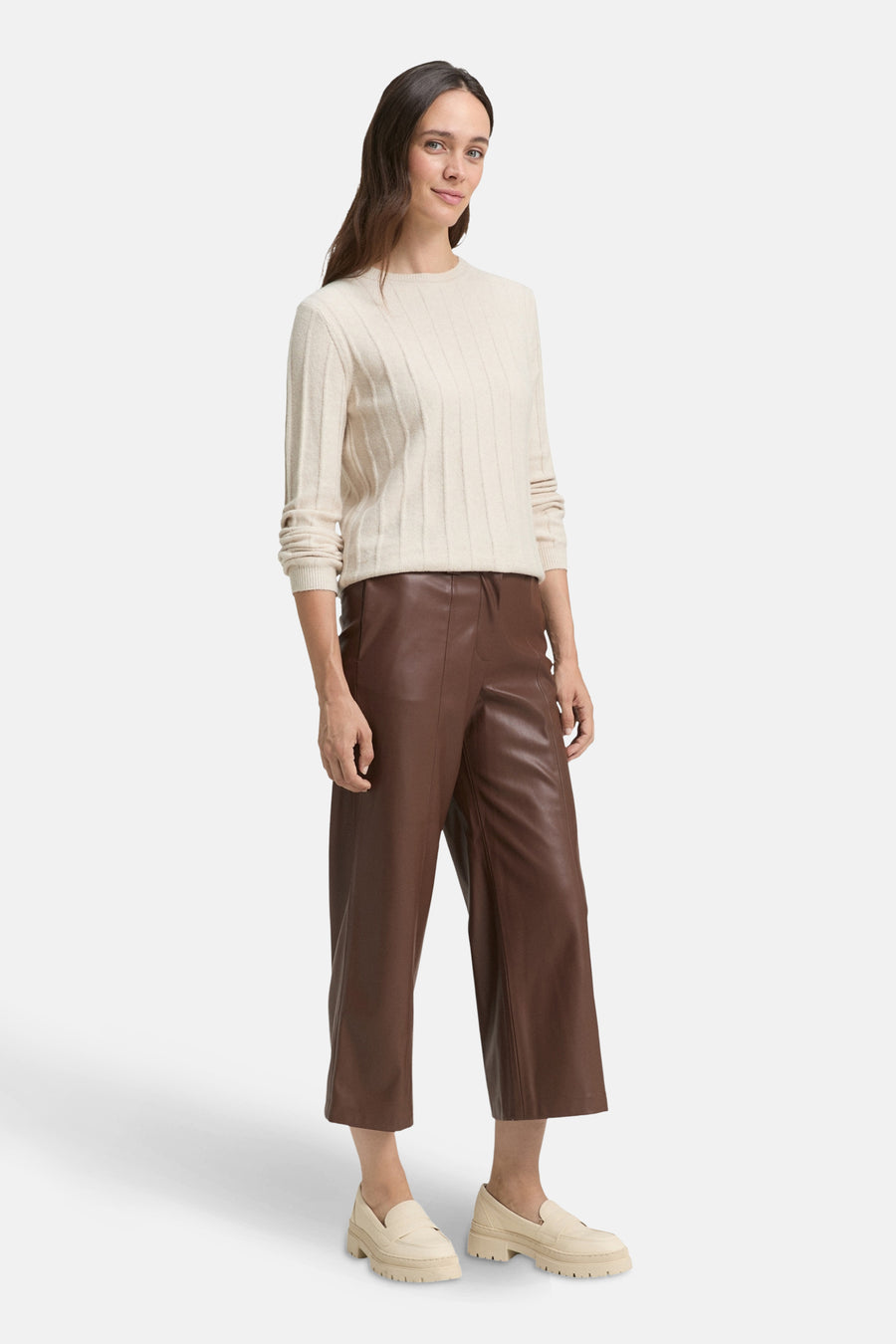 Pantalon brun en similicuir de Tom Tailor, porté avec un pull beige et des mocassins plateforme.
