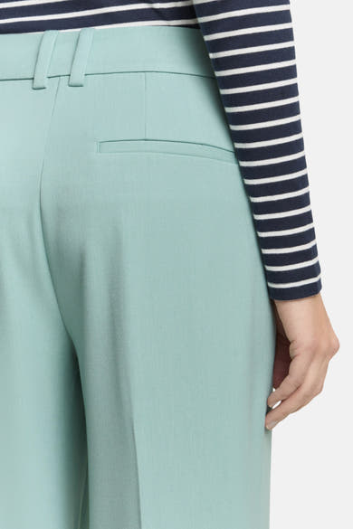 Pantalon de costume vert de Tom Tailor, avec une poche arrière discrète, porté avec un haut rayé marine et blanc.
