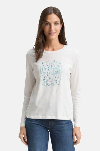 T-shirt à manches longues blanc de Tom Tailor avec un motif graphique bleu, porté avec un jean.