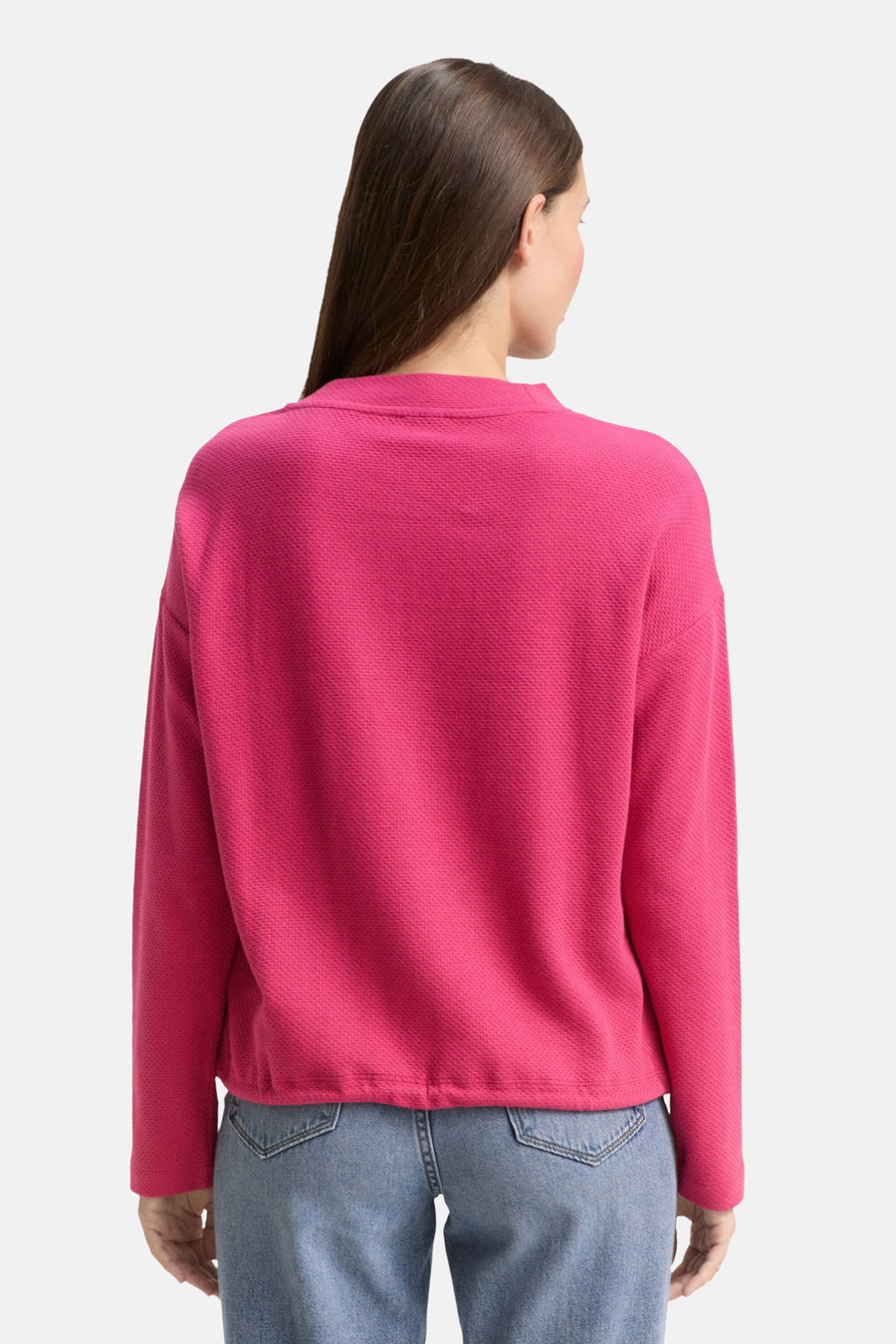 Sweat rose col rond de Tom Tailor, texture gaufrée, porté avec un jean taille haute.
