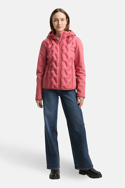 Veste courte rose by Tom Tailor avec une texture matelassée à losanges et un capuche. Porté avec un jean bleu et des bottes noires.