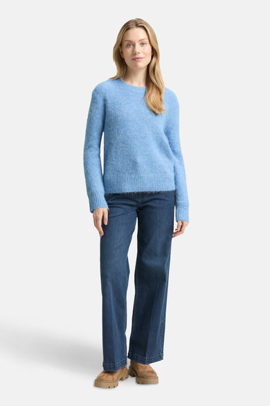 Blauwe trui met ronde hals van Tom Tailor, gedragen met een wijde jeans en bruine enkellaarsjes.