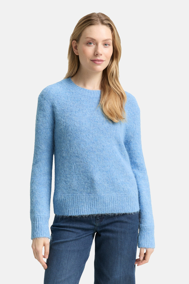 Ronde hals trui blauw van Tom Tailor, in pluizige brei, gedragen met een spijkerbroek.