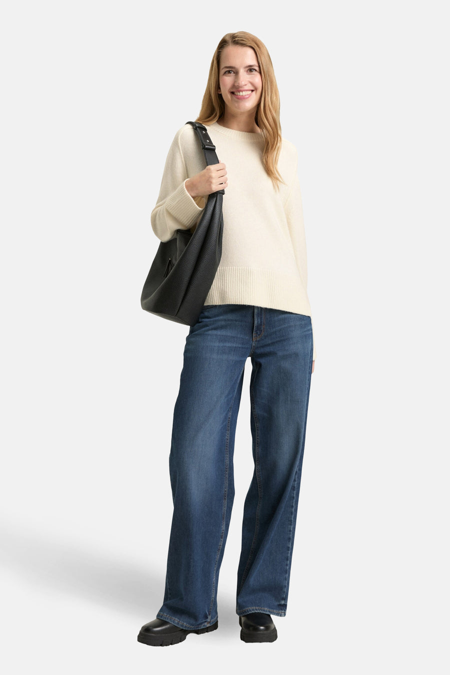 Pull à col rond blanc de Tom Tailor, porté avec un jean ample et un sac noir.