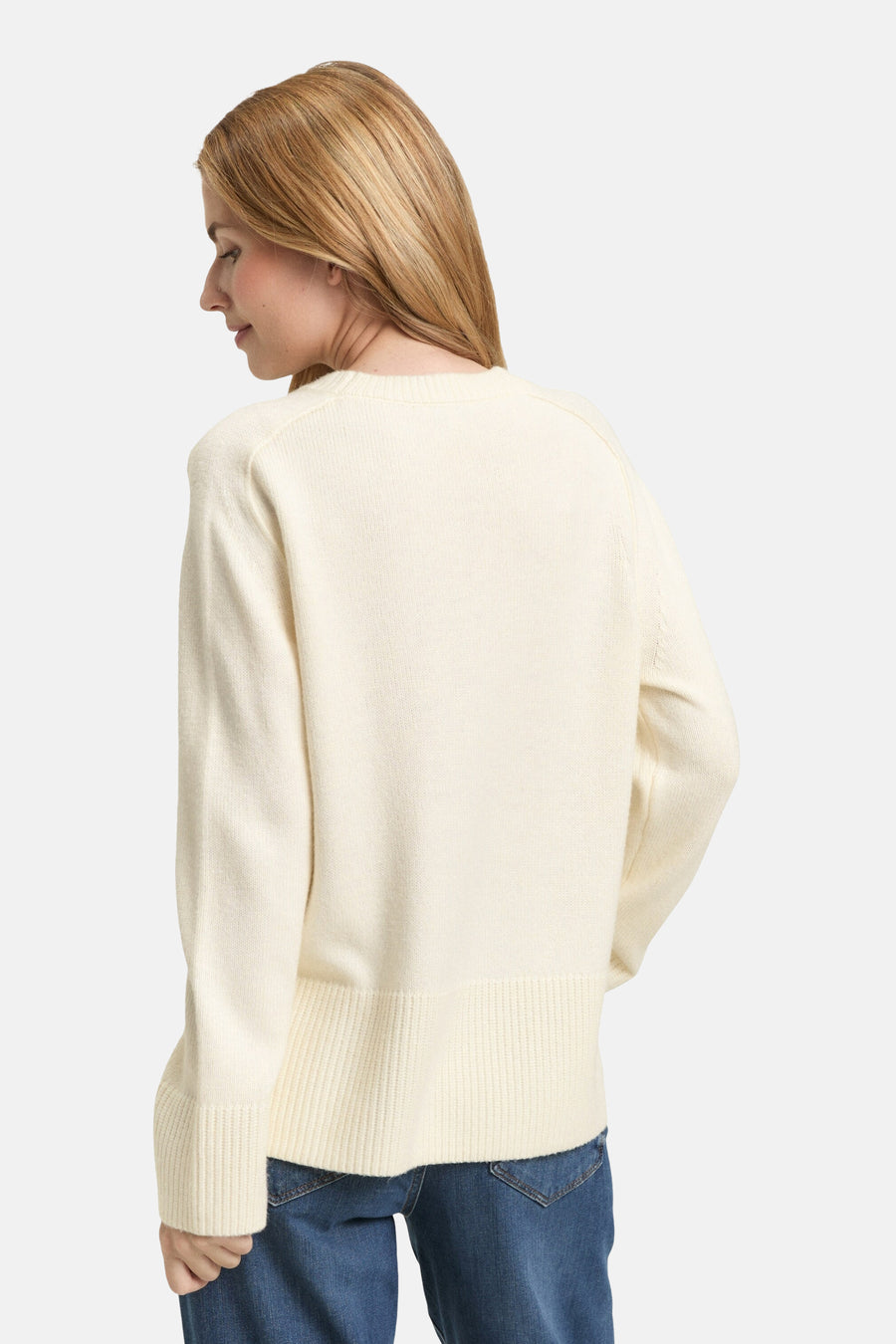 Pull à col rond blanc de Tom Tailor, en tricot uni, porté avec un jean bleu.