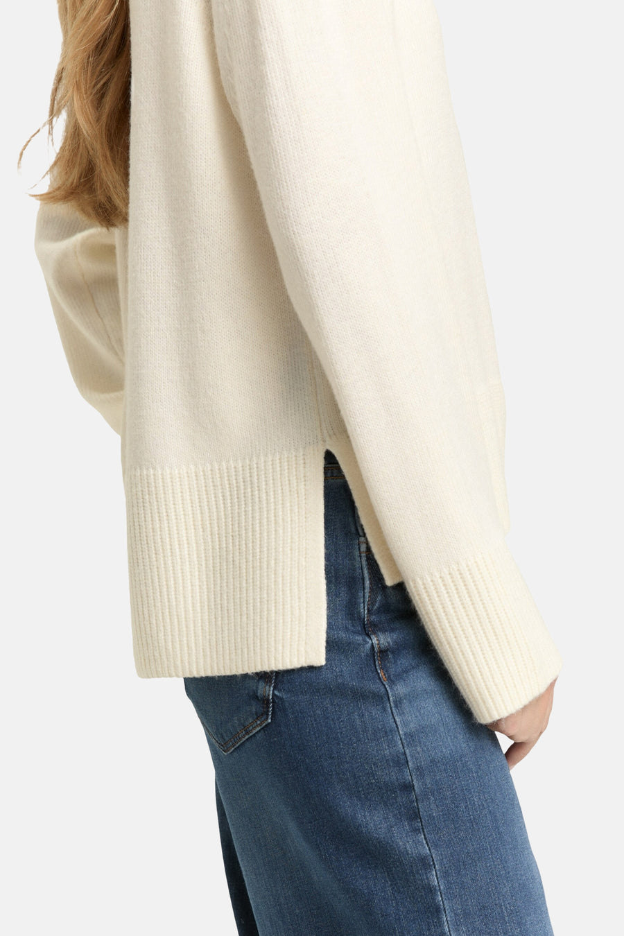 Pull à col rond blanc de Tom Tailor, en tricot, avec ourlet fendu et manches longues, porté avec un jean bleu.