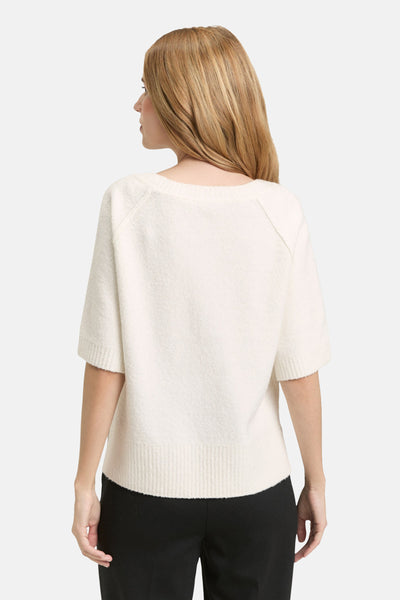 Witte rondehals trui van Tom Tailor, korte mouwen, gedragen met een effen zwarte broek, achtergezicht.