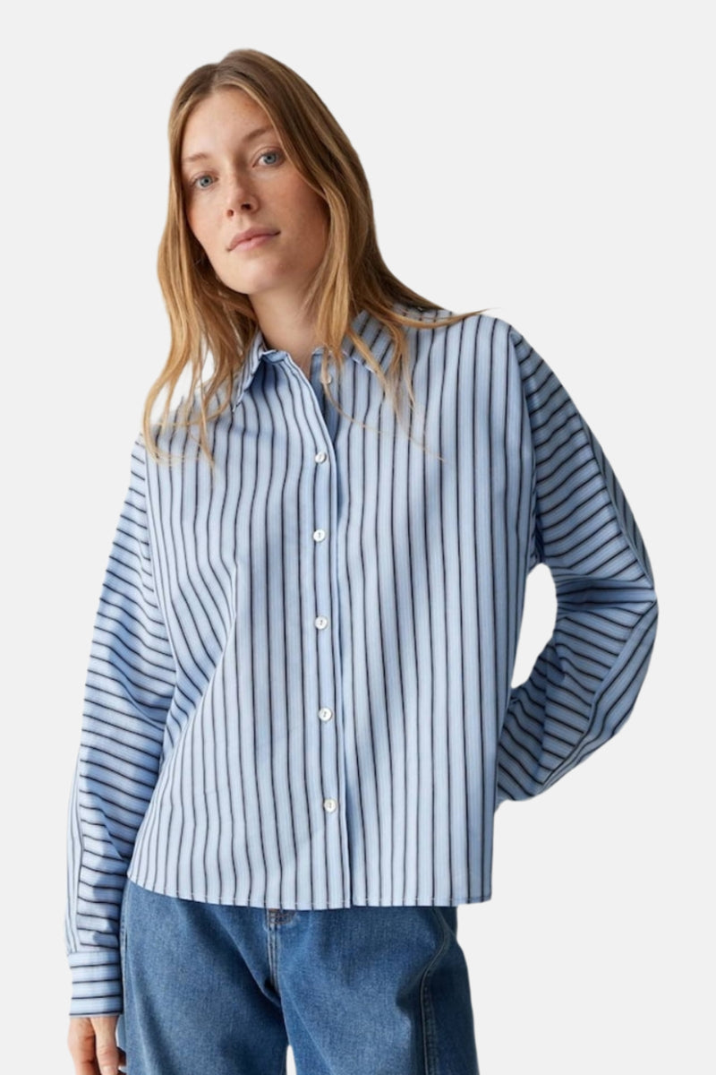 Chemise à manches longues bleue à rayures, de OPUS, portée avec un jean bleu.