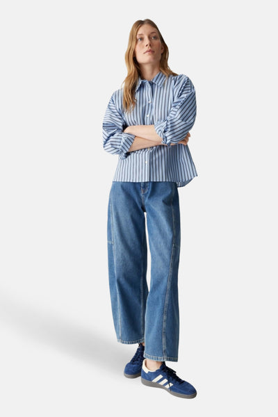 Chemisier à manches longues bleu rayé de OPUS, porté avec un jean bleu et des baskets bleues.