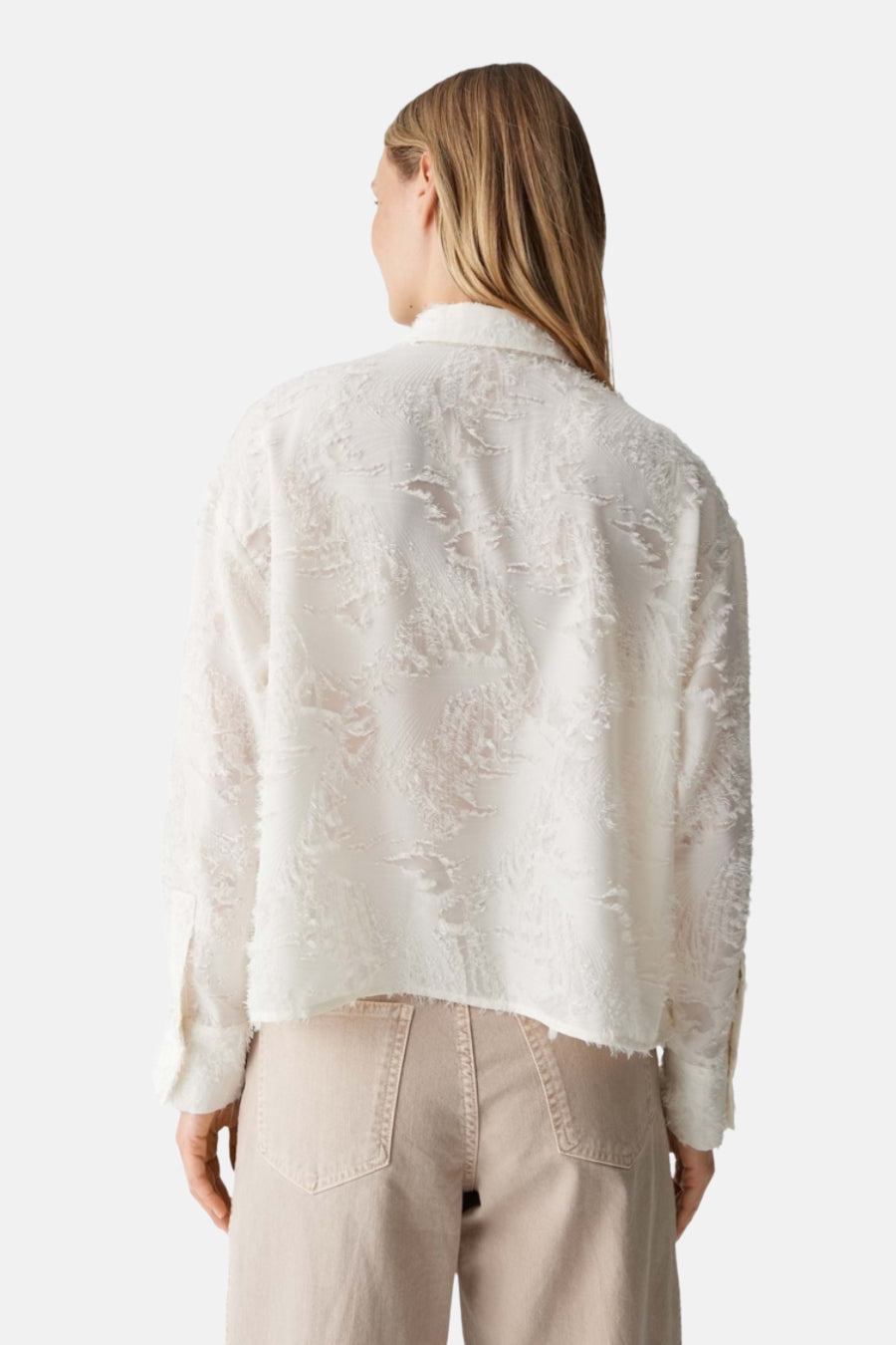Chemise à manches longues beige de OPUS, texturée avec motif abstrait, vue de dos, portée avec un pantalon couleur sable.
