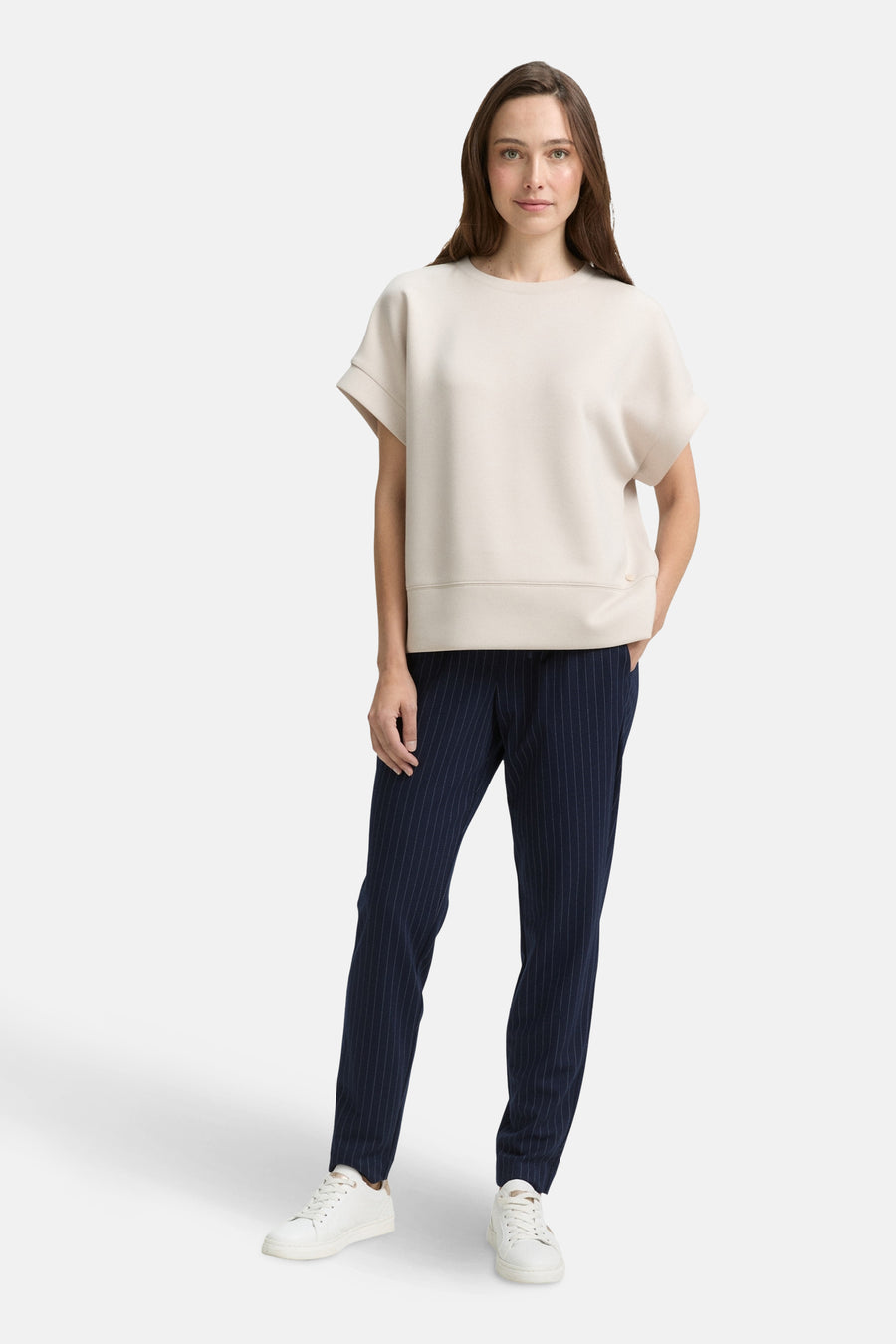 Blauwe gestreepte broek van Tom Tailor, gedragen met een gebroken witte top en witte sneakers.