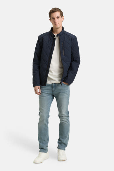Veste courte bleue de Tom Tailor avec motif matelassé, portée sur un t-shirt blanc et un jean décontracté.