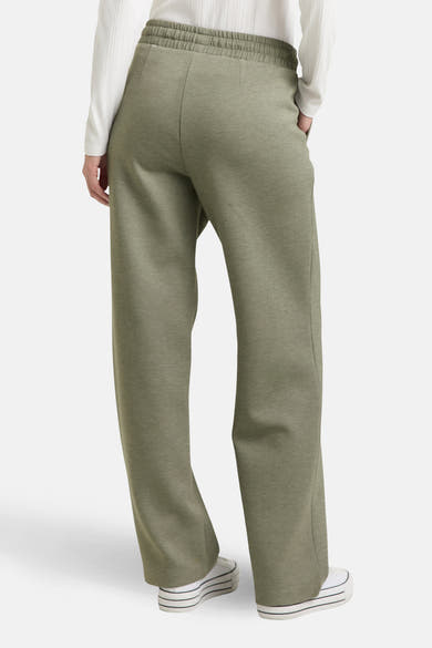 Jogging vert de Tom Tailor, coupe ample et taille élastiquée, porté avec un pull blanc.