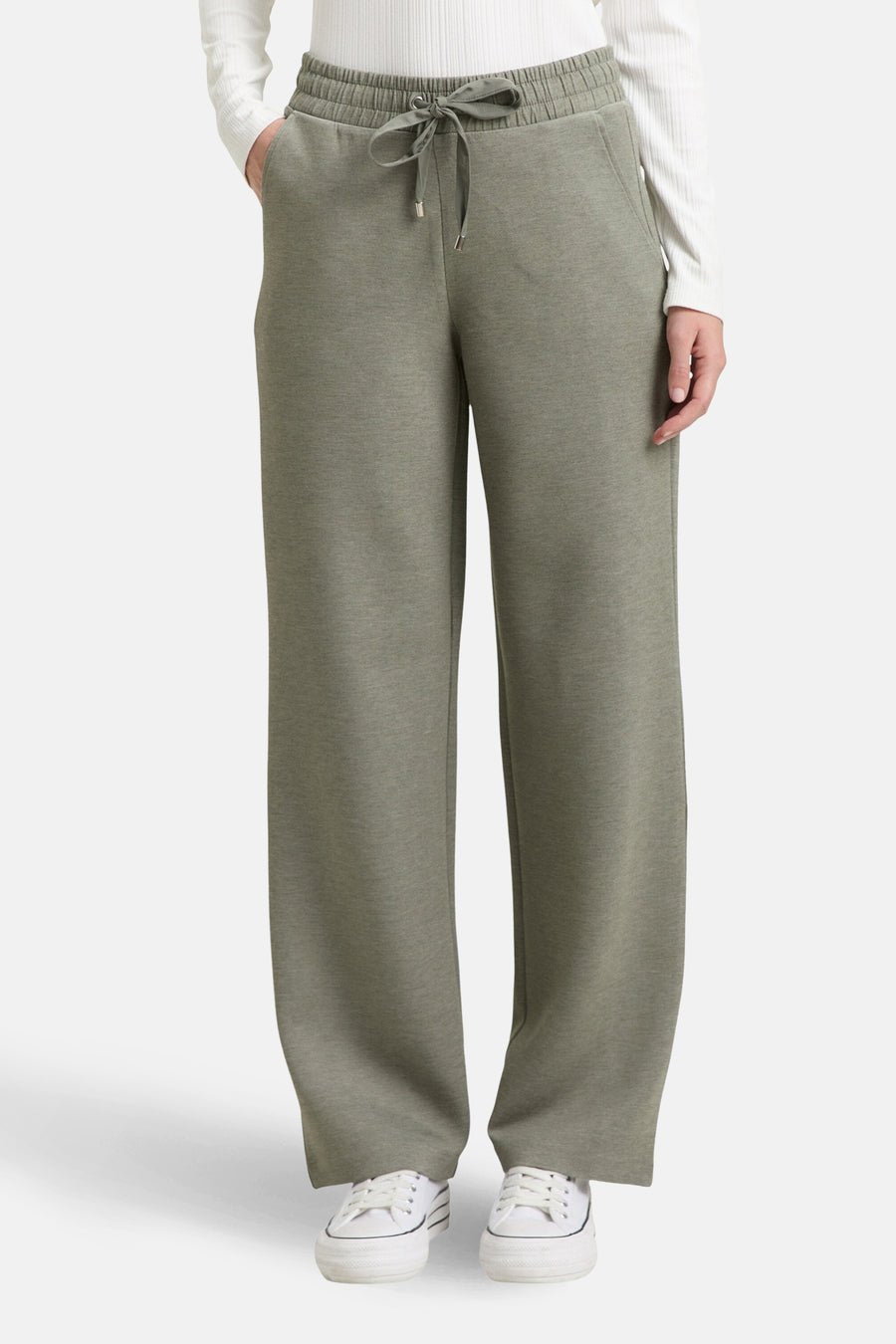 Jogging vert de Tom Tailor, avec cordon de serrage à la taille et porté avec un haut blanc.
