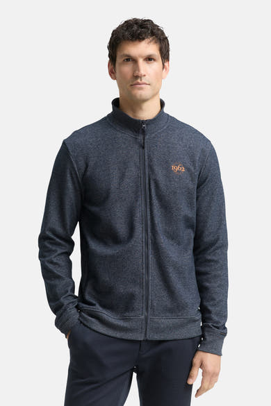 Blauwe gemêleerde bodywarmer van Tom Tailor, van achteren gezien, gedragen met een bijpassende broek.