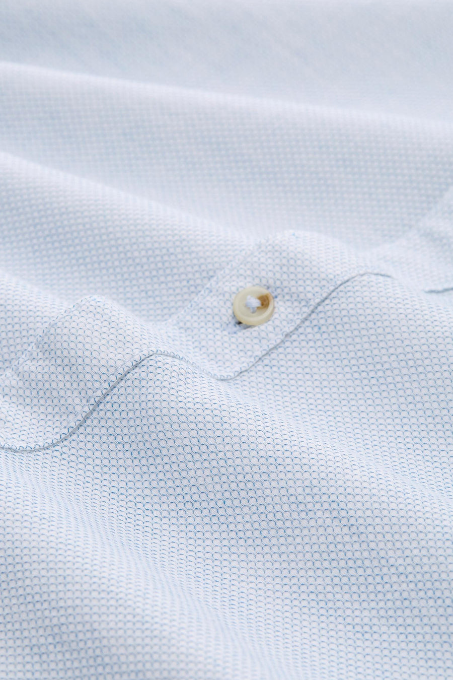 Chemise à manches longues bleue de Tom Tailor avec motif géométrique et texture froissée, détail du bouton.