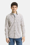 Chemise à manches longues multicolore de Tom Tailor, avec motif géométrique discret, portée sur un t-shirt blanc et un jean bleu.
