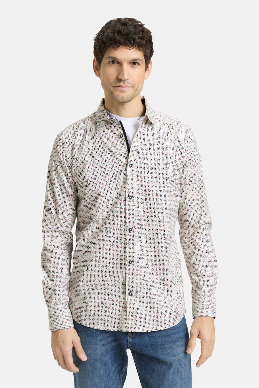 Chemise à manches longues multicolore de Tom Tailor, avec motif géométrique discret, portée sur un t-shirt blanc et un jean bleu.
